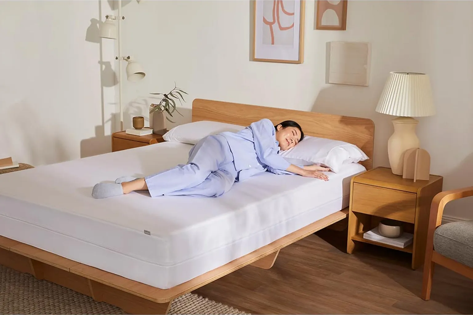 薄い夏掛けを使い、通気性のよい枕で横向きに眠る人の寝室イメージ
